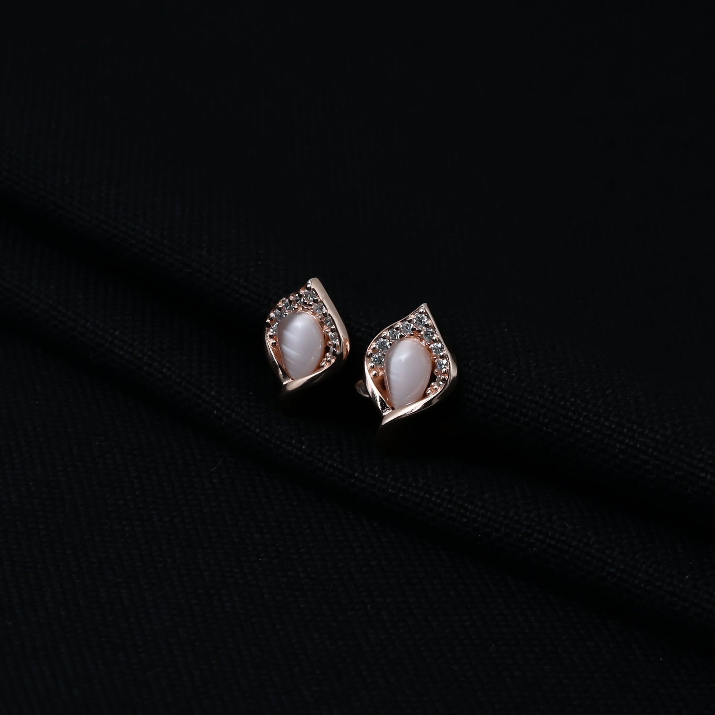 Stylish silver earrings with a leaf design and opal at the center