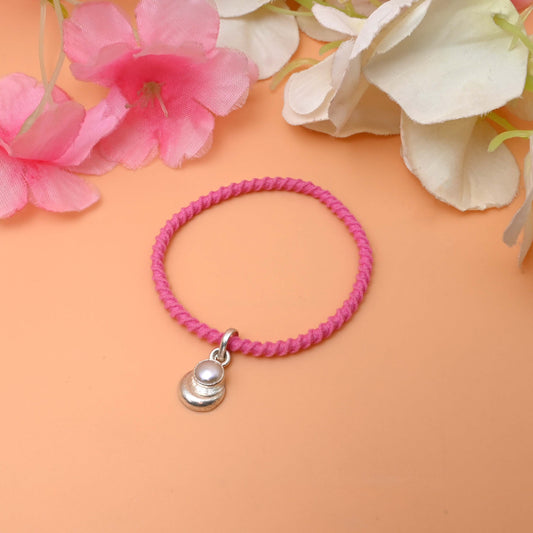 A Black/pink string bracelet featuring a delicate silver charm