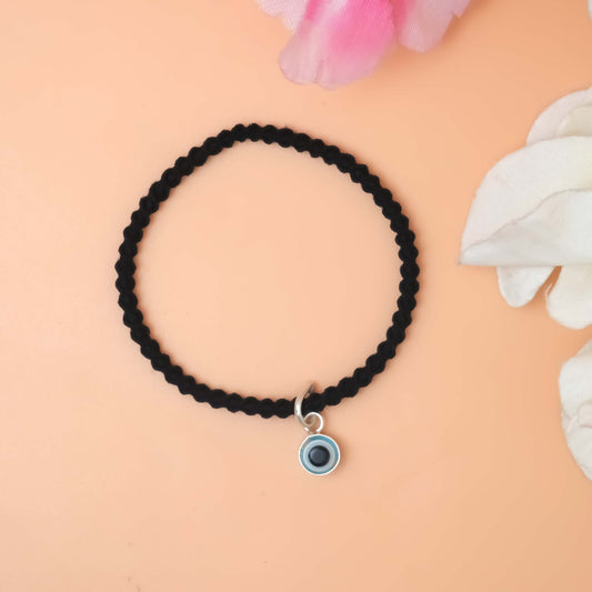 A stylish black bracelet featuring a silver evil eye charm
