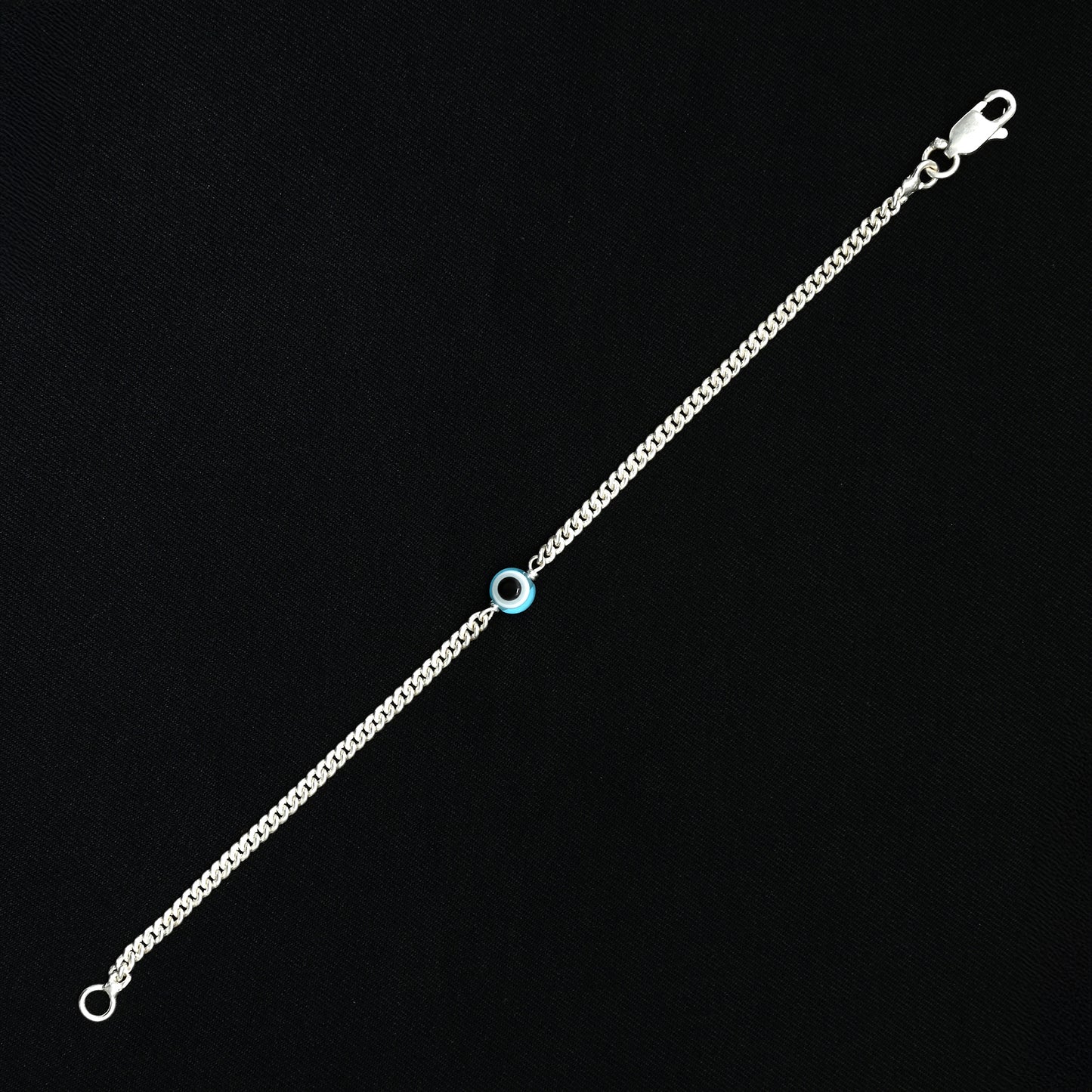 Elegant silver bracelet featuring a light blue evil eye for protection.