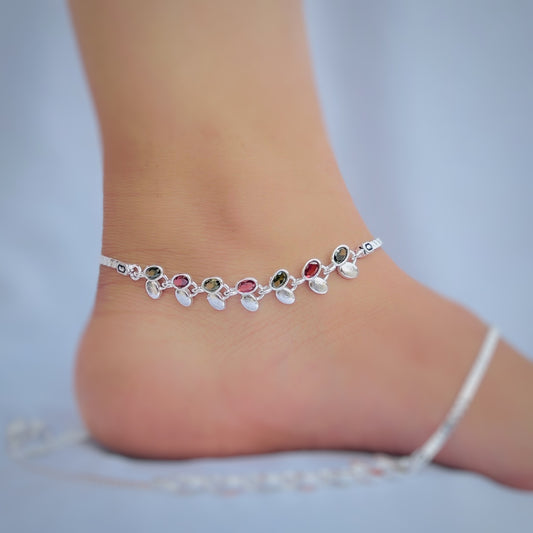 Silver anklet featuring red and green stones, leaf details, and silver buds.
