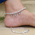 Silver anklet with lotus design and silver beads.