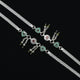 Trendy silver anklet with eye-catching dual green hearts and floral motifs.