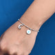 Elegant sterling silver bracelet adorned with a moon and evil eye charm.