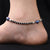 Stylish silver anklet with dual heart and evil eye charms.