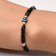 Girls' bracelet featuring a blue evil eye design and black beads in sterling silver.