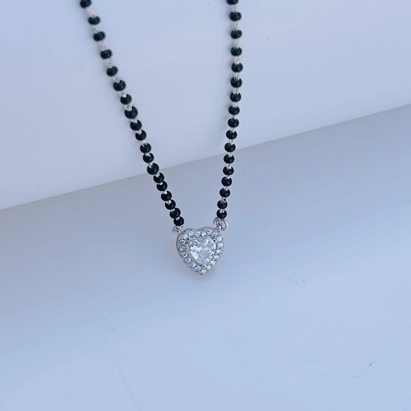 Black beads mangalsutra featuring heart-shaped stone pendant.