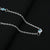 Silver chain adorned with blue evil eye beads for protection.