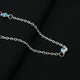 Silver chain adorned with blue evil eye beads for protection.