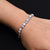 Boys' bracelet with a sterling silver band adorned with evil eye and flower motifs.