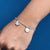 Elegant silver bracelet with a butterfly and evil eye motif.