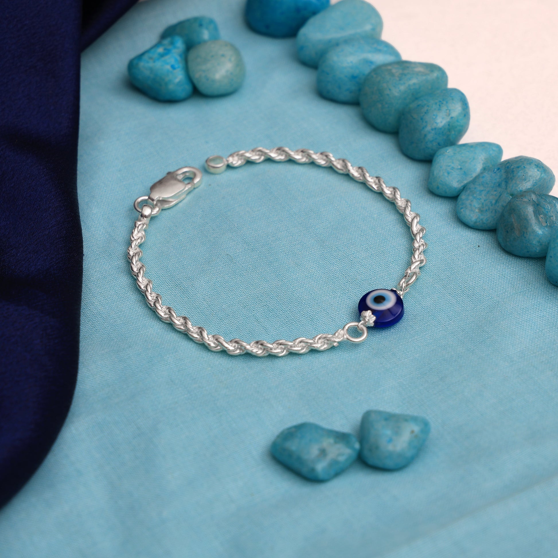 Silver bracelet featuring a sleek chain and an evil eye charm