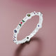 Charming silver bangles featuring purple and green gems.