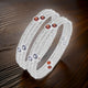 Stylish silver bangles with sparkling multicolor stone accents.