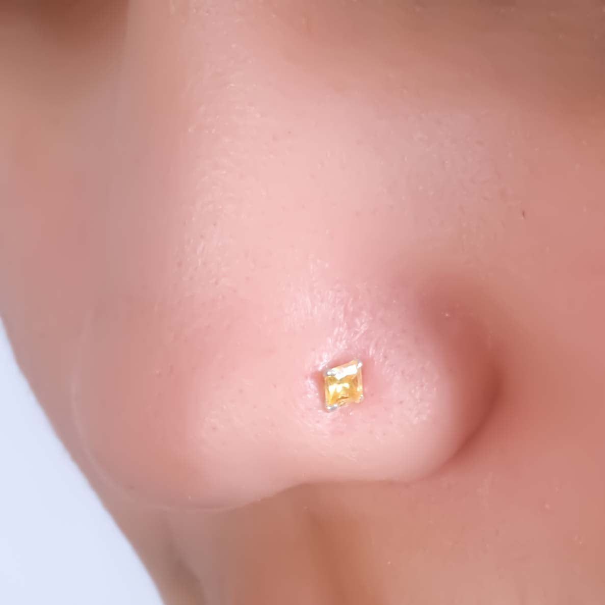 Vibrant silver nosepin with yellow gem