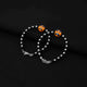 Stylish silver bracelet with an orange teddy bear design and black and silver beads.