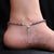 Silver anklets featuring pink and green beaded bird charms for girls.