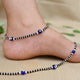 Silver payal featuring a blue evil eye charm with black and silver beads.