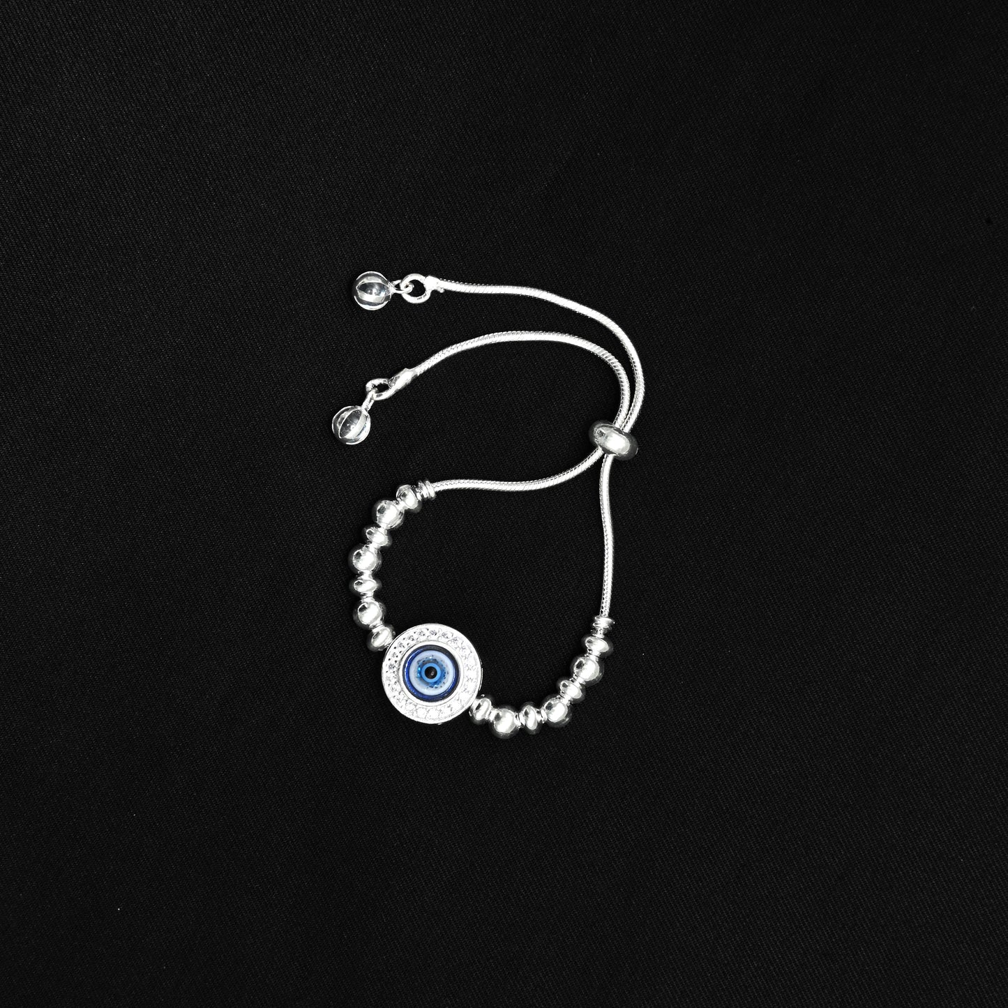 Stylish silver bracelet with floral patterns and evil eye for protection.