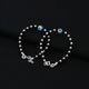 Stylish silver bracelet showcasing a light blue evil eye and a mix of black and silver beads.