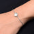 Girls' bracelet with a sterling silver band adorned with a pearl and fish motif.