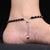 Silver anklet with heart and green evil eye.